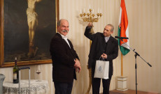 Varga János atya átadja az előadóművésznek ajándékként a kis harangot