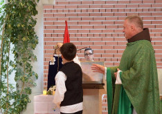 A müncheni egyházközség egy gyermeke koronát helyez a Gyermek Jézus-szoborra, melyet Csaba testvér hozott magával körútja során